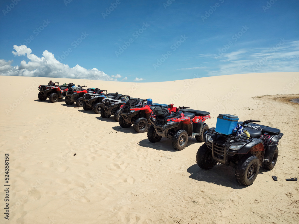 Beautiful view to group of quad bike riders on sand dunes Beautiful view to group of quad bike riders on sand dunes