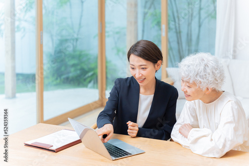 パソコンで説明する営業マンとシニア女性（ビジネス・保険） photo