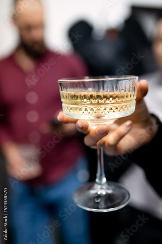 female hand holding a glass of white sparkling champagne