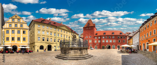 Panoramaansicht des  Heidplatz in Regensburg mit Justitiabrunnen und seinen angrenzenden historischen Gebäuden bei Sonnenschein und aufgelockerter Bewölkung photo