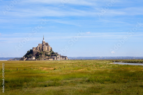 Beautiful panoramic view of famous Le Mont Saint-Michel tidal island with blue sky. Normandy, northern France © Susana