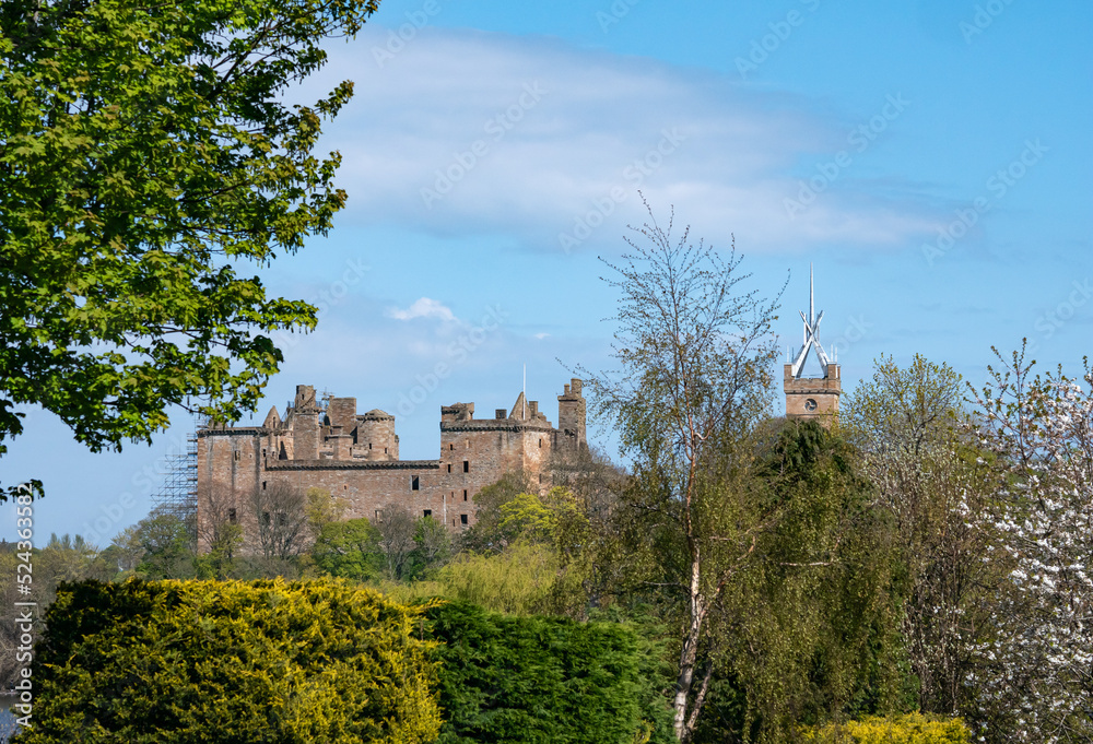 Linlithgow Palace on a hill view through trees in spring