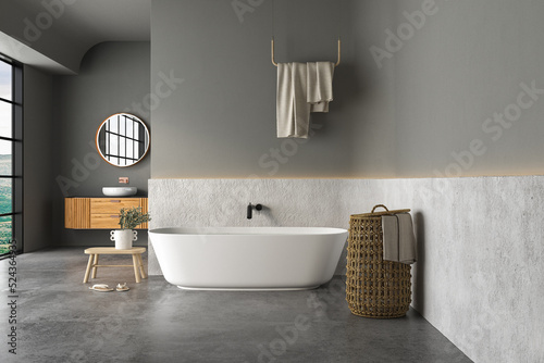 Interior of modern bathroom with white and dark walls  concrete floor  bathtub  indoor plants  white sink standing on wooden countertop and a oval mirror hanging above it. 3d rendering 