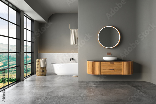 Fototapeta Naklejka Na Ścianę i Meble -  Interior of modern bathroom with white and dark walls, concrete floor, bathtub, indoor plants, white sink standing on wooden countertop and a oval mirror hanging above it. 3d rendering
