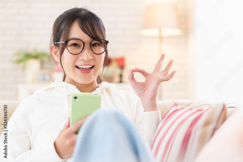 部屋でスマホを見る女性 部屋でスマホを見る女性