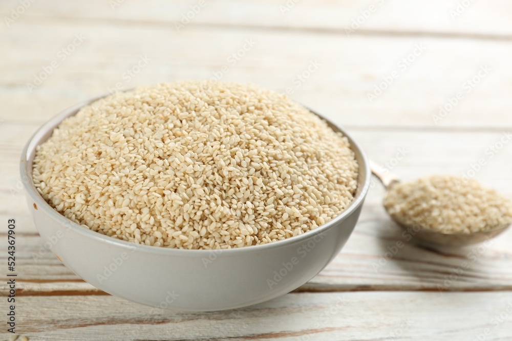 White sesame seeds on wooden table, closeup White sesame seeds on wooden table, closeup