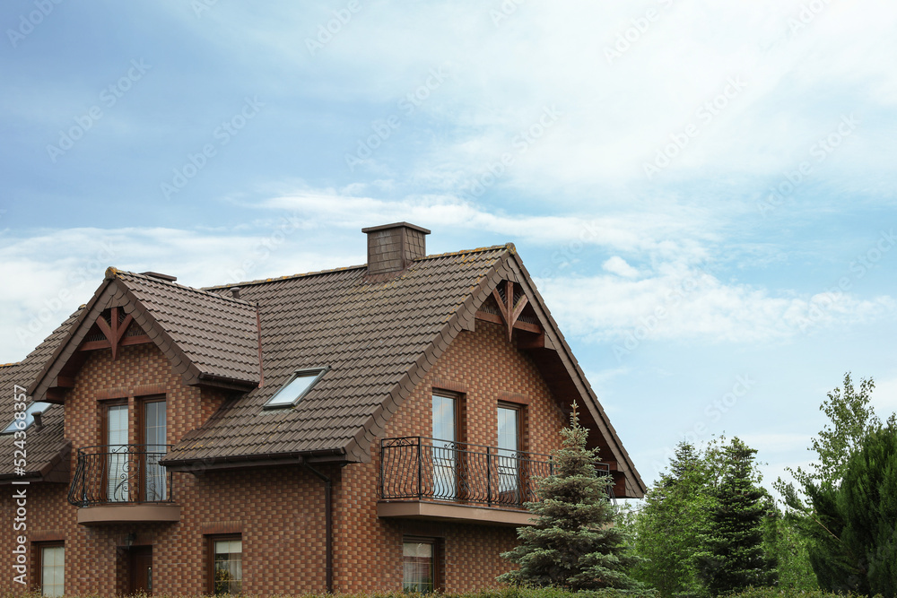 Beautiful house with brown roof against blue sky