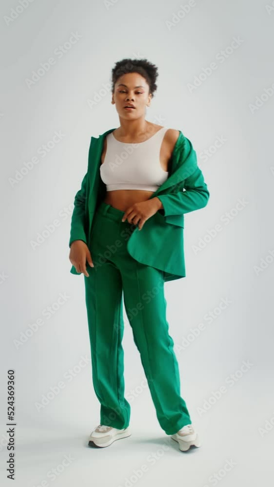 Woman in a green jacket posing on a white background, vertical video Woman in a green jacket posing on a white background, vertical video