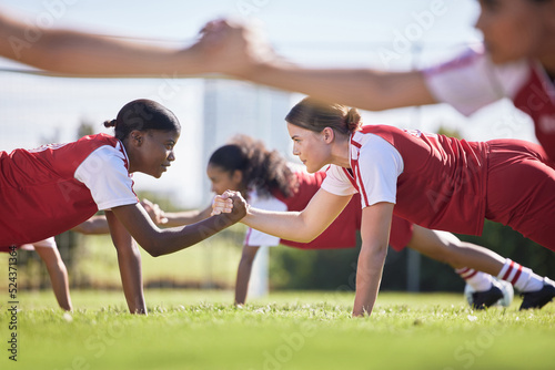 Fototapeta Naklejka Na Ścianę i Meble -  Women soccer, football or team sports holding hands in unity, support or motivation in routine workout, exercise or training drill. Diverse group of fit, active or healthy athletes and girls on field