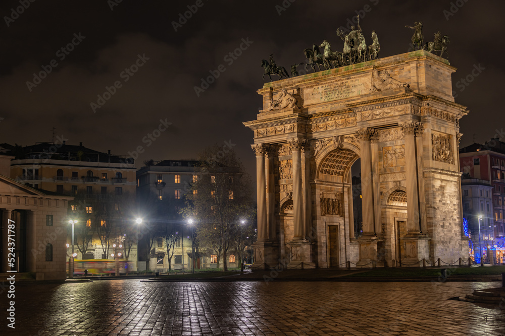 statue of monarch on arch of triumph of milan at night with horses