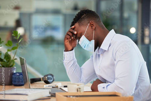 Canvas Print Business man tired, sick and ill with covid at work sitting at a desk and wearing a mask with a headache