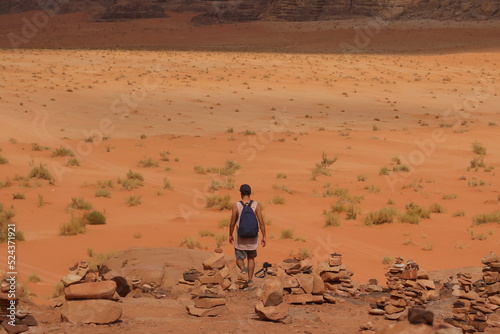 Hombre caminando en el desierto de espaldas en las rocas