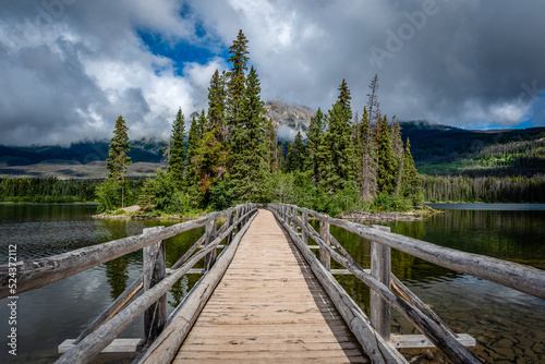 Blue sky appearing through low clouds over the Pyramid Lake Island bridge in Jasper National Park, Alberta