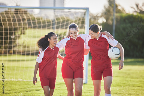 Fun female football players or friends in sportswear hugging, smiling and bonding together after practicing on a field. Young, sport and athletic soccer girls talking about good and exciting match