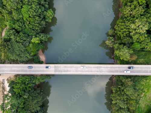 Downward aerial view of tropical river bridge with cars passing over © AspectDrones