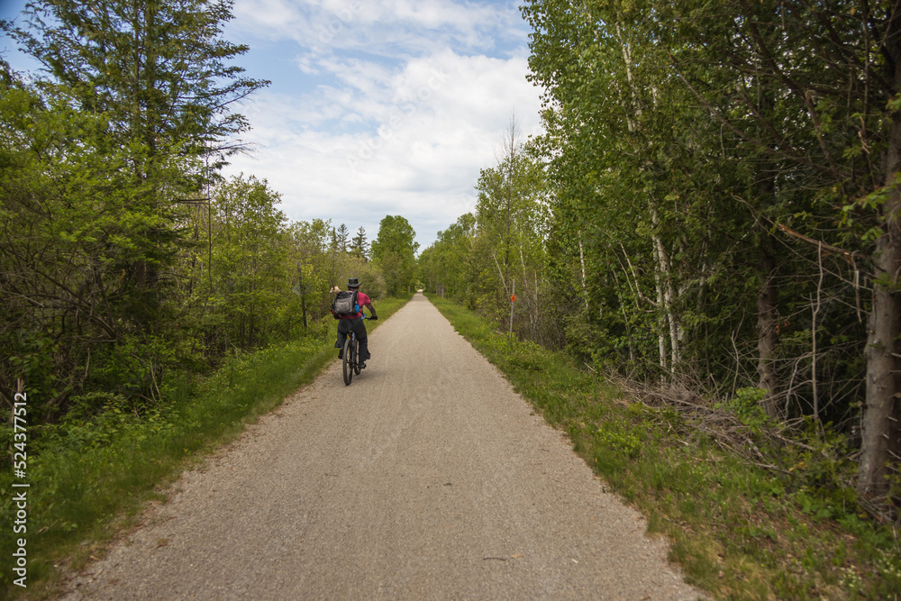 Man with a dog in a backpack riding a bicycle