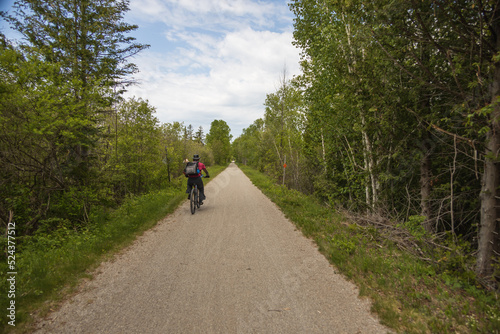 Man with a dog in a backpack riding a bicycle