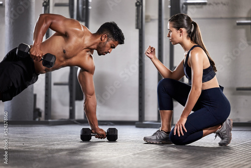 Training  exercise and motivation with a fitness coach or personal trainer and her bodybuilder student during a workout in the gym. Health  sports and wellness with a heathy athlete exercising