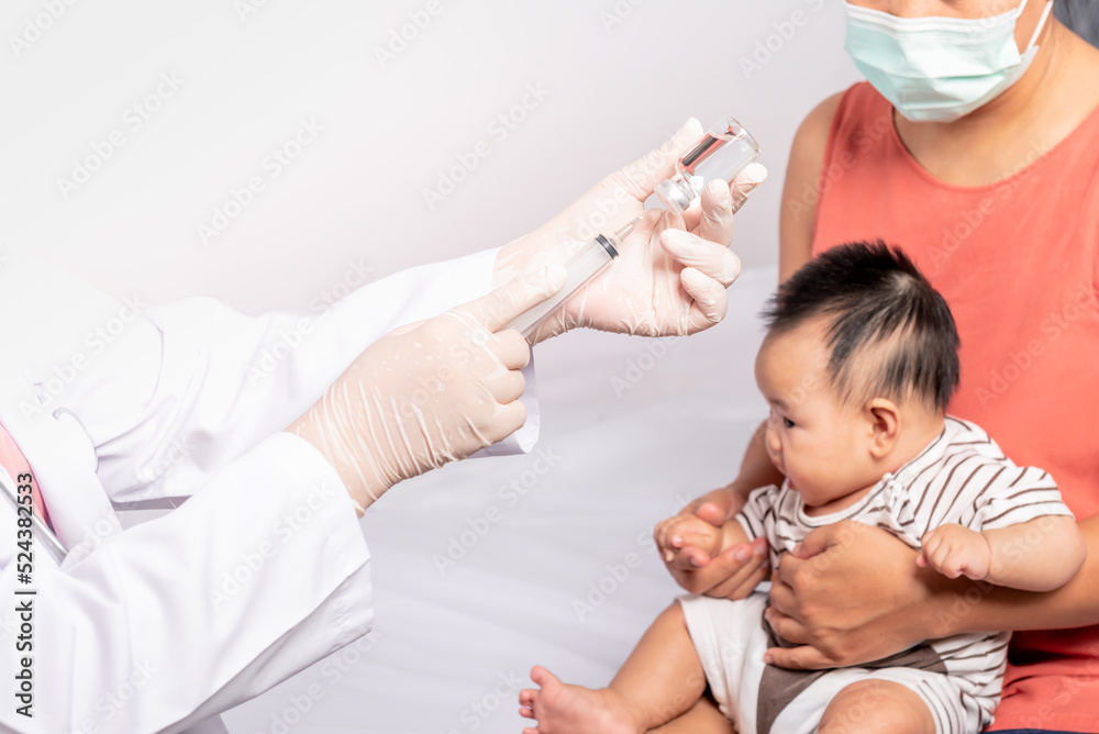 Close-up images, Doctor's hand which prepares to vaccinate against virus, with blur background of mother is holding baby newborn is 3 montsh old, to baby newborn health care and vaccine concept. Close-up images, Doctor's hand which prepares to vaccinate against virus, with blur background of mother is holding baby newborn is 3 montsh old, to baby newborn health care and vaccine concept.