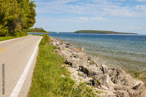 Two lane road on Mackinac Island with Lake Huron and Round Island in background  Michigan