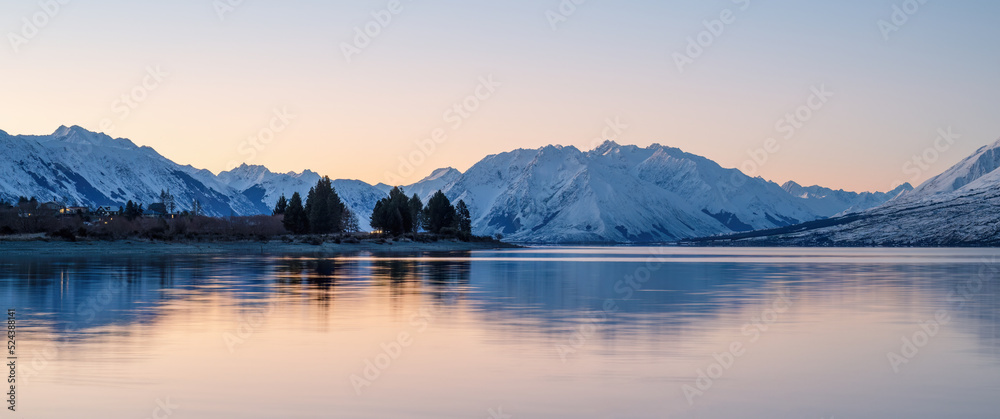Snow-capped mountain range reflected in Lake Ohau at sunset, Twizel, South Island.