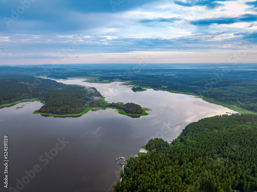 Fototapeta Naklejka Na Ścianę i Meble -  Big lake with green shores with morning fog in dawn, aerial landscape. Recreation concept. Aerial view