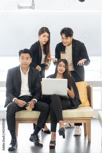 Happy office concept - concentrated business team with laptop computers in office. Happy Business team of entrepreneurs working together. Funny moment in business.