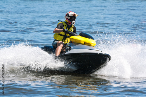 man running a jet ski in the waves with water splash photo