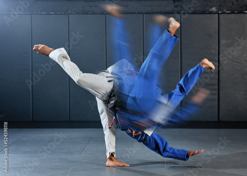 Fitness, strength and men in a karate fight in a gym for martial arts exercise. Action, motion and learning to take down the competition, training to overcome, fight failure and the motivation to win photo