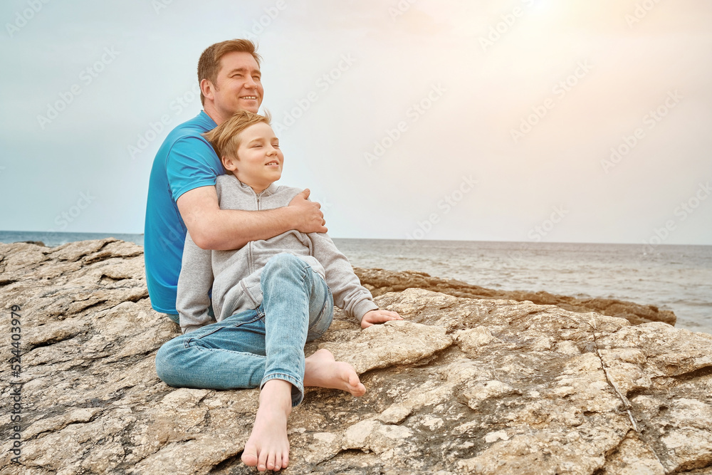 Happy family, father and son bonding, sitting on stone by the sea looking at view enjoying summer vacation. Togetherness Friendly concept
Happy family, father and son bonding, sitting on stone by the sea looking at view enjoying summer vacation. Togetherness Friendly concept