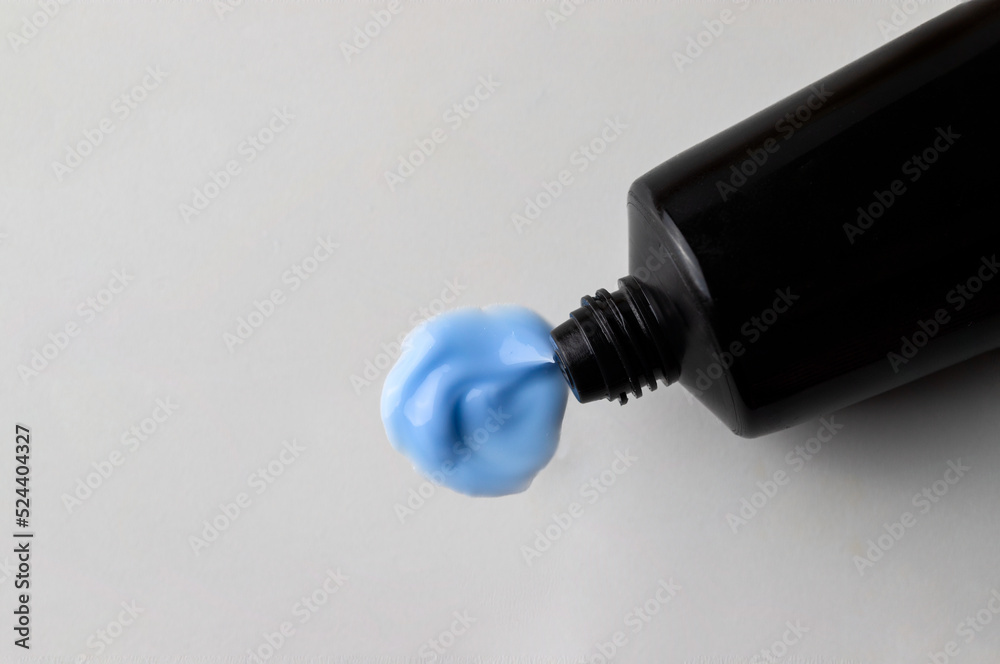 Black cream tube with product smear con beige background. Cosmetic texture image .copy space Black cream tube with product smear con beige background. Cosmetic texture image .copy space