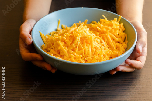 grated cheddar cheese on a plate on wood table