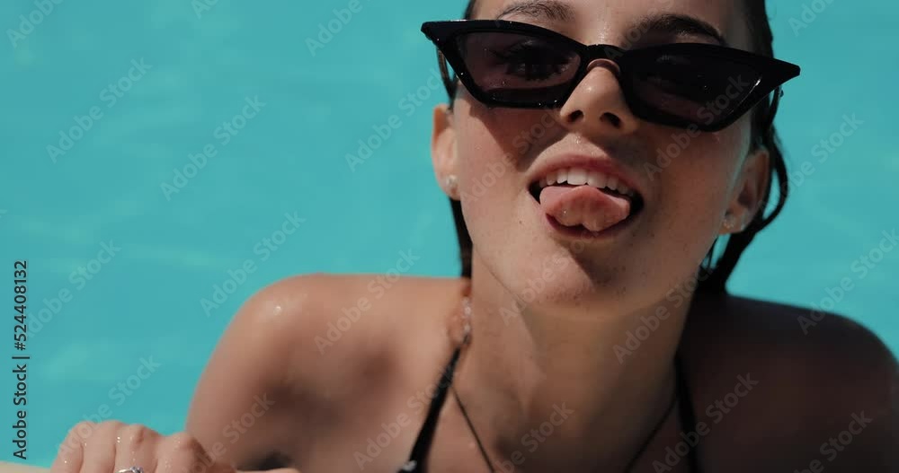 Beautiful woman showing tongue in the swimming pool, slow motion Beautiful woman showing tongue in the swimming pool, slow motion