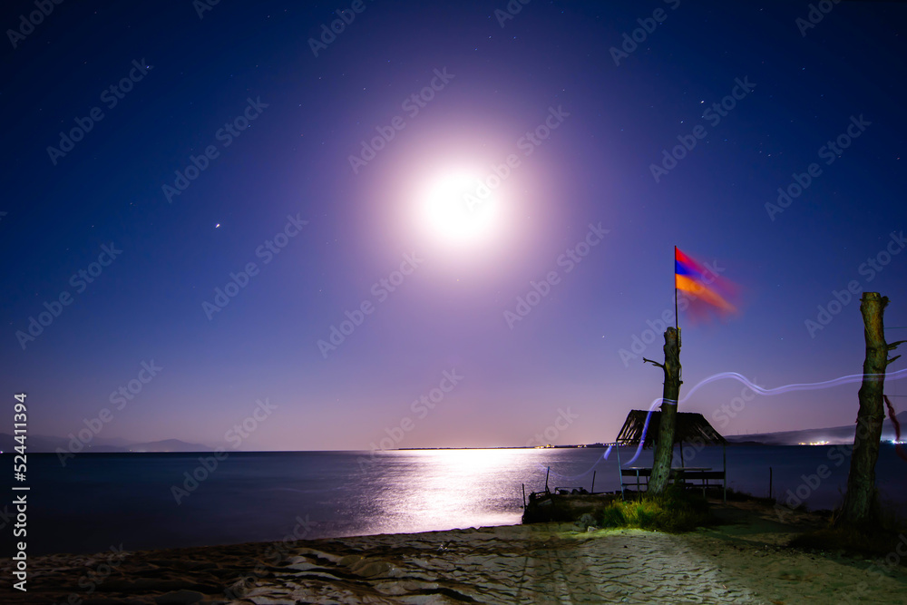 Reflection of the moon on the waters of the sea. Lunar day, bright night sky, shining stars, sea and white sand