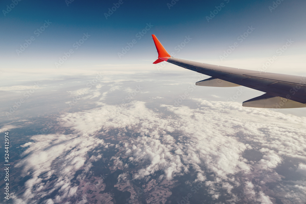 Airplane wing view from the window during a flight on vacation or on business. Beautiful sky and curved winglet for fuel economy Airplane wing view from the window during a flight on vacation or on business. Beautiful sky and curved winglet for fuel economy