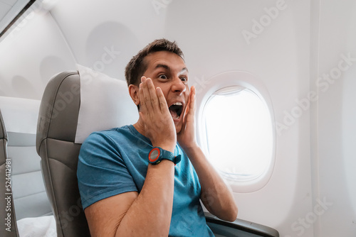 Photography Young man is afraid to fly on an airplane and emotionally screams in fear