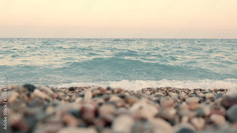 Light blue sea and rocky beach at sunset close up view Light blue sea and rocky beach at sunset close up view