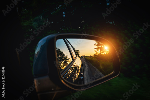 Trip sunset car mirror. Sun, highway car road reflection in mirror. Summer holidays trip concept.