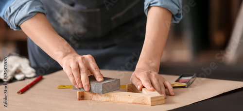 Female carpenter smoothing planks in workshop  closeup