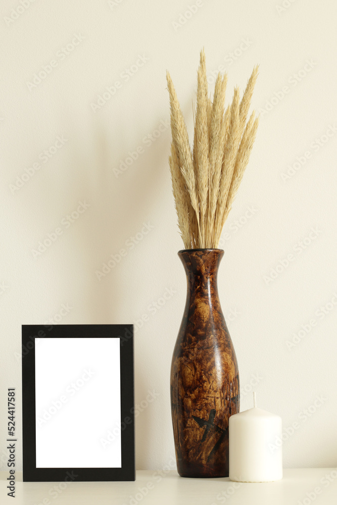 old black frame mockup with brown vase and white candle on table