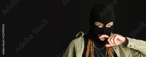 Photo Young woman in balaclava on black background with space for text