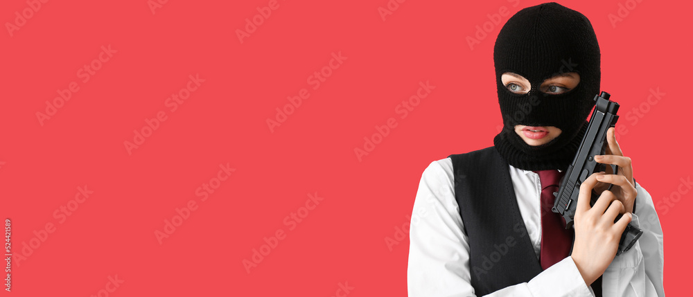 Portrait of young woman in balaclava and with gun on red background with space for text Portrait of young woman in balaclava and with gun on red background with space for text