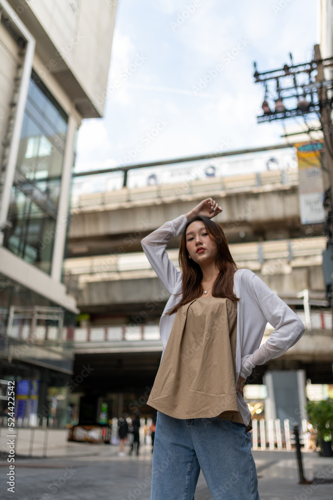 Lifestyle portrait photo of a beautiful young asian lady relax and posing around the city after a long pandemic lockdown