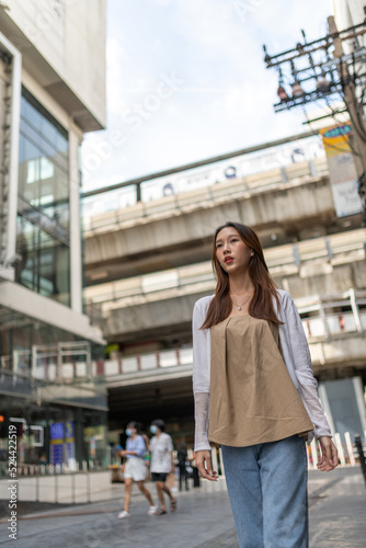 Lifestyle portrait photo of a beautiful young asian lady relax and posing around the city after a long pandemic lockdown