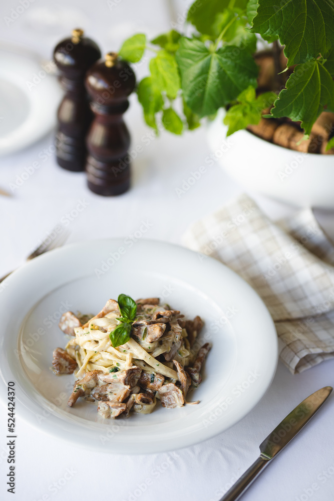 Appetizing Italian pasta with mushrooms on a light background.