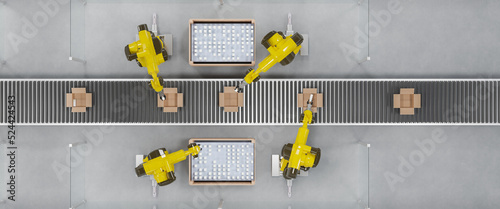 Robots at a conveyor belt packing items into cardboard packages. Top view.