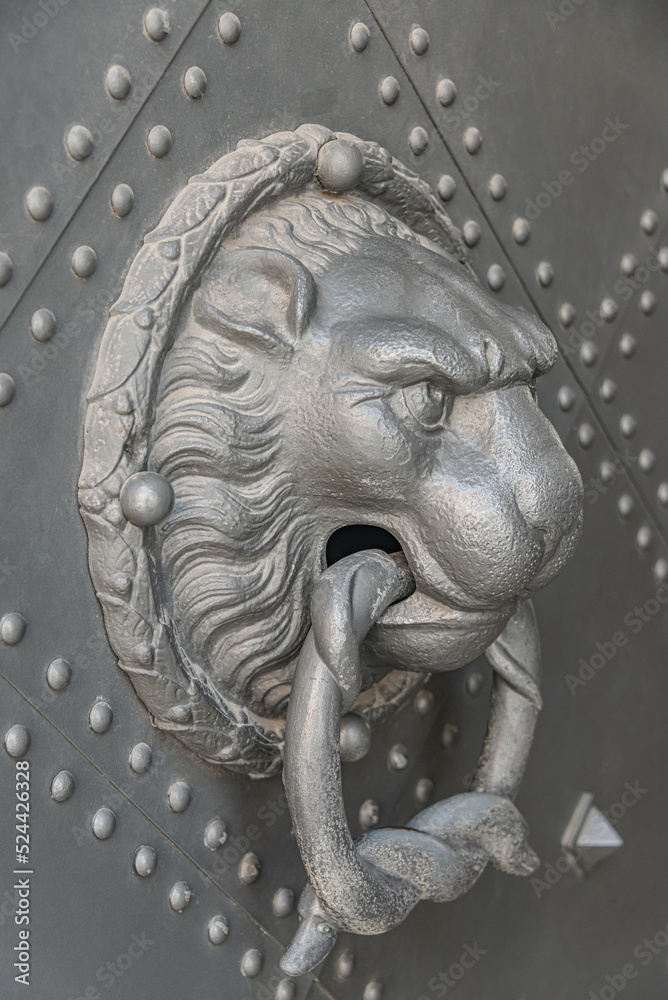 Ancient middle age iron door handle with a lion muzzle and ring, closeup, details. Ancient middle age iron door handle with a lion muzzle and ring, closeup, details.