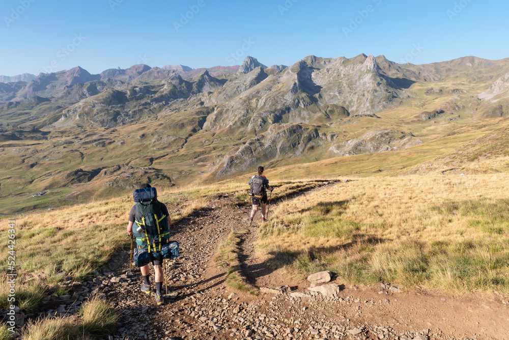 Fototapeta premium Hikers descending towards Anéou. Ossau Valley