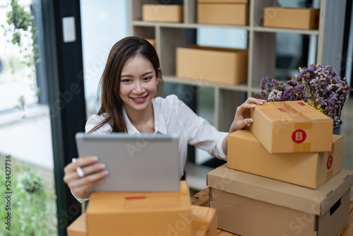 Portrait business Asian woman with parcel shipping box before send to customer. Entrepreneur small business working at home.