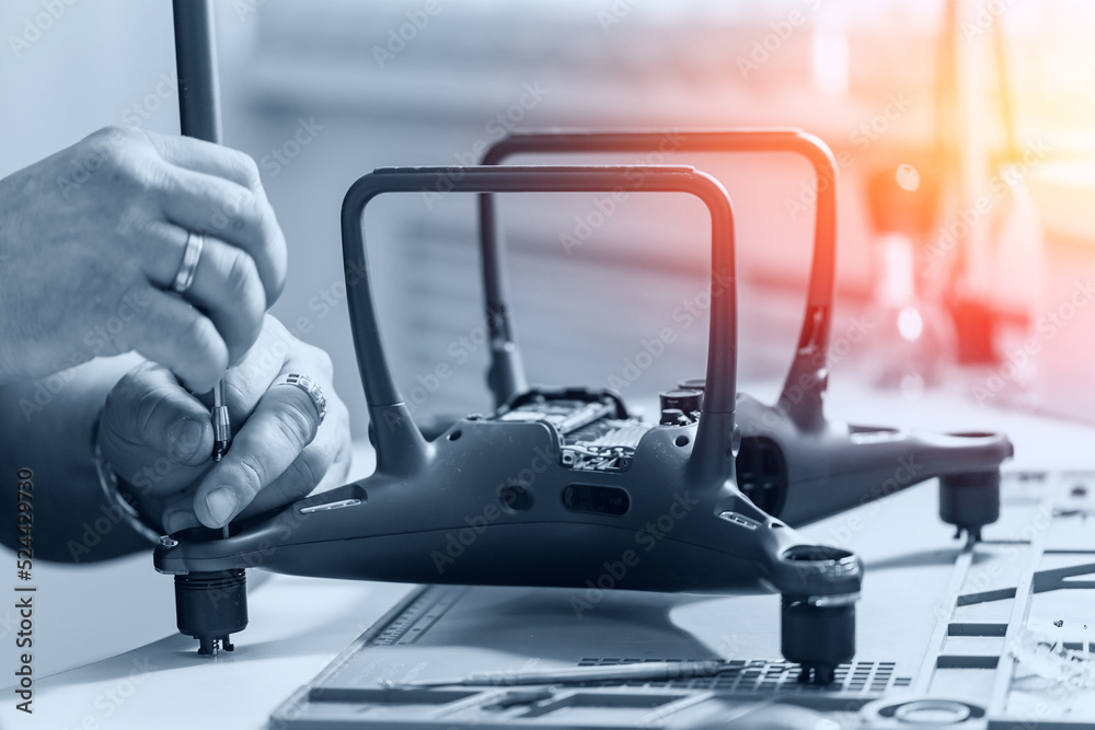 Professional repair of RC drones and radio controlled cars, robots.Broken quadrocopter lies on workshop Professional repair of RC drones and radio controlled cars, robots.Broken quadrocopter lies on workshop